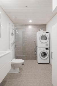 uma casa de banho com um WC e uma máquina de lavar roupa em New LUXUS 3BR Helsinki Home em Helsinque