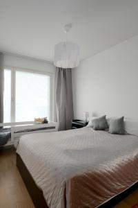 a white bedroom with a large bed and a window at New LUXUS 3BR Helsinki Home in Helsinki