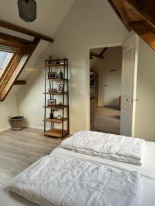 een wit bed in een kamer met een zolder bij Ruim appartement met sauna, Zuidstraat 125 in Westkapelle in Westkapelle