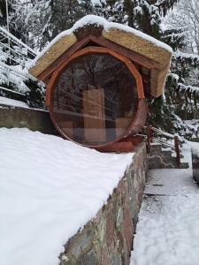 a bird feeder in a snow covered yard at Dom nad jeziorem Ublik z sauną i jacuzzi in Ublik
