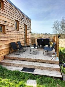 a wooden deck with chairs and a table on it at tiny house in Saint-Vallier