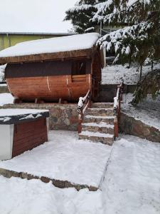 une maison avec de la neige au sol et des escaliers dans l'établissement Dom nad jeziorem Ublik z sauną i jacuzzi, à Ublik