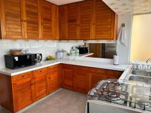 a kitchen with wooden cabinets and a sink and a stove at La mejor ubicación de Viña in Viña del Mar