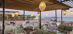 ein Restaurant am Strand mit Stühlen und Lichtern in der Unterkunft L'azure Beach Resort in Khuraybah