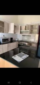 a kitchen with white cabinets and a stove top oven at KingdomHomes. in Kigali