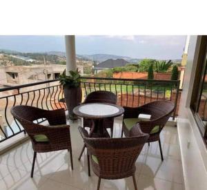 a patio with a table and chairs on a balcony at KingdomHomes. in Kigali