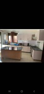 a large kitchen with white cabinets and appliances at KingdomHomes. in Kigali