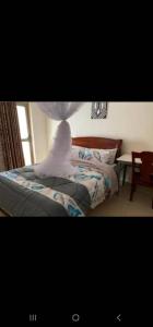 a bedroom with a bed with a white object on it at KingdomHomes. in Kigali