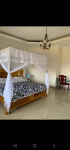 1 dormitorio con 1 cama con edredón blanco y negro en KingdomHomes., en Kigali