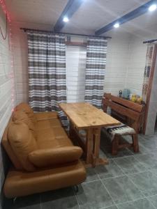 Cette chambre comprend une table, un canapé, une table et un banc. dans l'établissement Goryanka, à Yaremtche