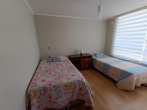 a bedroom with two beds and a window at Departamento La Serena in La Serena +4 photos