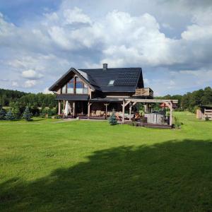 a house with solar panels on top of a green field at Stacja Jacnia in Jacnia