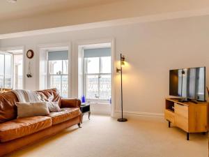 a living room with a couch and a flat screen tv at The Penthouse Westhaven Aberdyfi in Aberdyfi