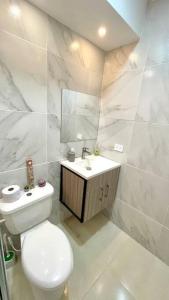 a white bathroom with a toilet and a sink at Apartamento con vista a las montañas, cerca Centro Comercial Mayales in Valledupar
