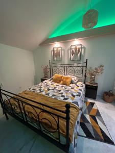 Cama en habitación con techo verde en Spa Jacuzzi Moon White, en Vaudherland