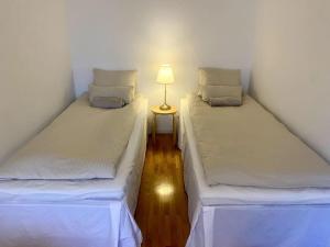 Duas camas individuais num quarto com um candeeiro. em Martin Helmi em Turku