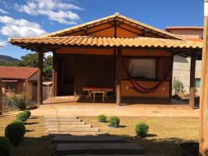 a house with a hammock under a roof at Chalé do Rogerio in Santana do Riacho