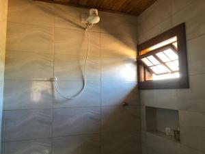 a shower in a bathroom with a window at Chalé do Rogerio in Santana do Riacho +9 photos