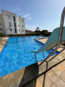 a chair sitting next to a swimming pool at Calma Marína Roses in Roses
