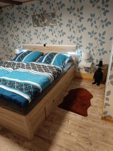 a bedroom with a bed with blue sheets and a black cat at Haus Luise in Stapelburg