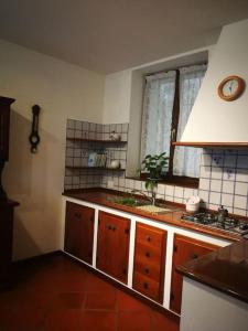 a kitchen with wooden cabinets and a sink and a window at Antica Dimora del Glicine in Rovereto