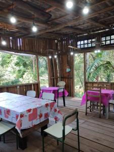 uma sala com mesas e cadeiras e mesas roxas em Pousada Recanto do Beija Flor em São José dos Pinhais