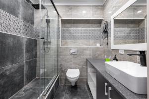 ein Badezimmer mit Toilette, Waschbecken und Dusche in der Unterkunft One Bedroom Apartment Near Arbat In The Heart of Almaty in Almaty + 21 Fotos