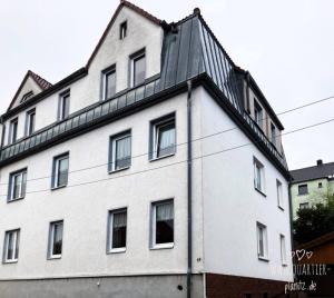 um edifício branco com um telhado preto em Quartier Planitz em Zwickau