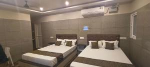 Cette chambre dispose de deux lits et de la climatisation. dans l'établissement Selvasi Beach Cottage, à Auroville