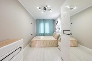 a small bedroom with a bed and a glass wall at Two Bedroom Apartment In The Heart of Almaty in Almaty