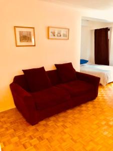 um sofá vermelho numa sala de estar com uma cama em Stylish Montreal Apartment: Comfortable Stay in the Golden Square Mile em Montreal