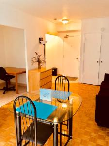 uma sala de estar com uma mesa de vidro e cadeiras em Stylish Montreal Apartment: Comfortable Stay in the Golden Square Mile em Montreal