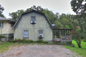 un antiguo granero con un porche en el patio en A simple and functional space for travelers, en Knoxville