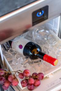 a bottle of wine in a refrigerator with grapes at Villa Jelena in Mlini