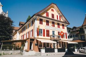 a large building with red shutters on it at Hotel Luzern Engel in Hitzkirch