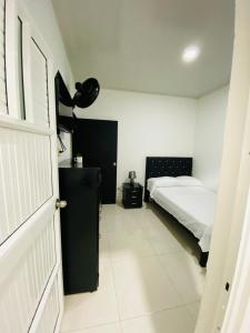a bedroom with a bed and a black door at Alojamientos Z.V in Tumaco