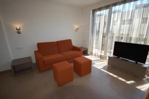 a living room with a couch and a flat screen tv at Resort Sitges Apartment in Sitges