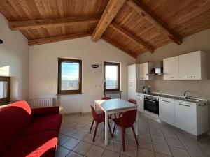 a kitchen and living room with a red couch and a table at Casa dell'amicizia in Castellani