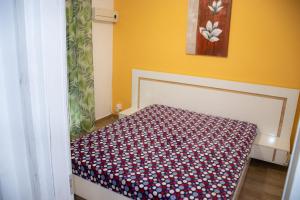 1 dormitorio con 1 cama con manta roja y blanca en george's house en Paralia Katerinis