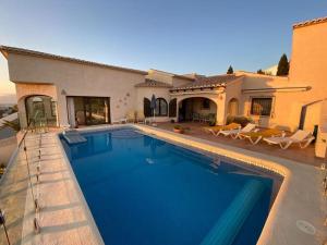 a swimming pool in front of a house at Casa Othello - Villa with private pool in Benitachell