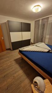 een slaapkamer met een bed met een blauw dekbed bij Doppelzimmer in FEWO Burgau Nähe Legoland in Burgau