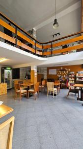 een bibliotheek met tafels en stoelen in een kamer bij Traveler Hostel in Shkodër
