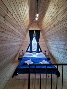 a bed in a wooden room with a window at Arsha View in Stepantsminda