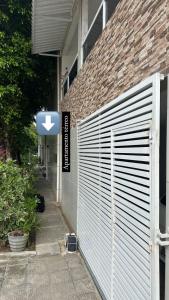 a white fence next to a building with a sign at Aero-Quarto Aconchegante in Bayeux