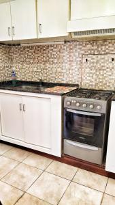 a kitchen with white cabinets and a stove at Lavalle II in Venado Tuerto