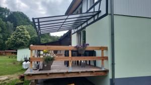 a wooden deck with potted flowers on a house at Ruridylle III in Simmerath