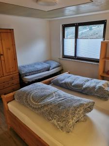 1 dormitorio con 2 camas y ventana en Ruridylle III en Simmerath