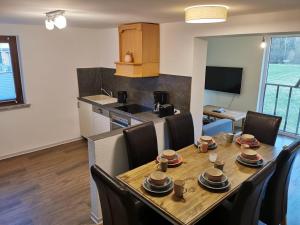 a kitchen and dining room with a table and chairs at Ruridylle III in Simmerath