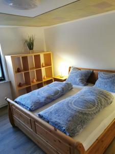 1 dormitorio con 2 camas y almohadas azules en Ruridylle III en Simmerath