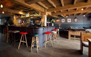 a bar with red stools in a restaurant at The Duke William in Littlebourne